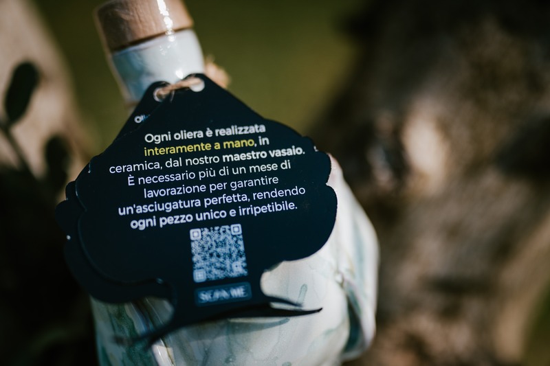 Etichetta sul retro di un Pumolio® in ceramica azzurra, con descrizione della lavorazione a mano